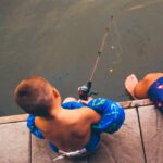 kid with floaties fishing