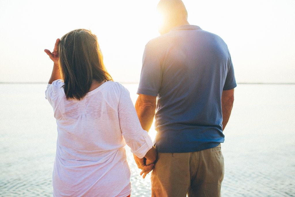 couple holding hands on the lake